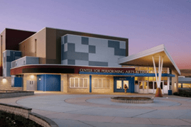 Modern Center for Performing Arts at twilight, showcasing its unique architecture and welcoming entrance. Ideal for cultural events and performances.